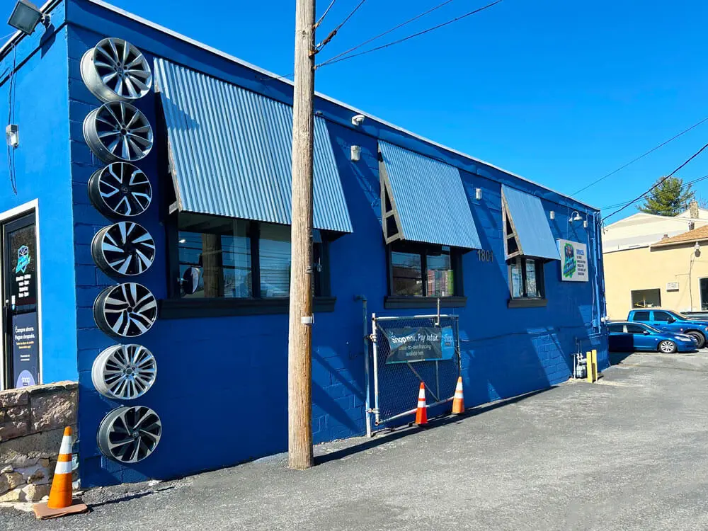 Front view of ProWheels Auto Repair & Mechanics shop in Bethlehem, PA with custom wheels displayed on the exterior wall